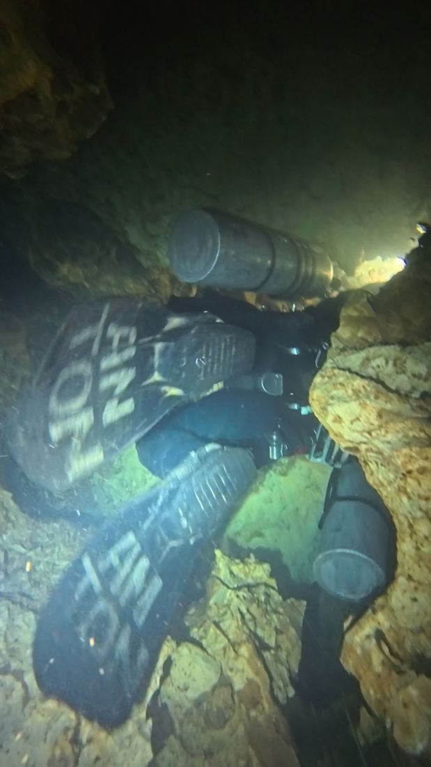 Cave dive seen from above in a narrow crack